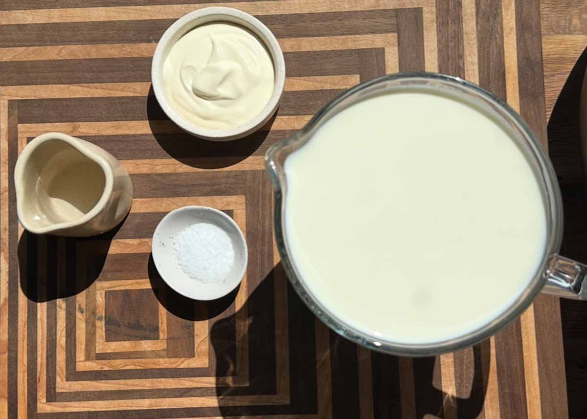 Ingredients for homemade cottage cheese including milk and vinegar