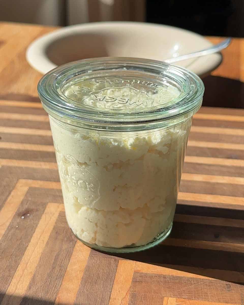 Bowl of freshly made cottage cheese in a marble kitchen