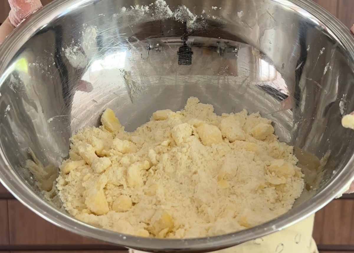 Butter rubbed into flour to create crumb texture for homemade galette pastry.