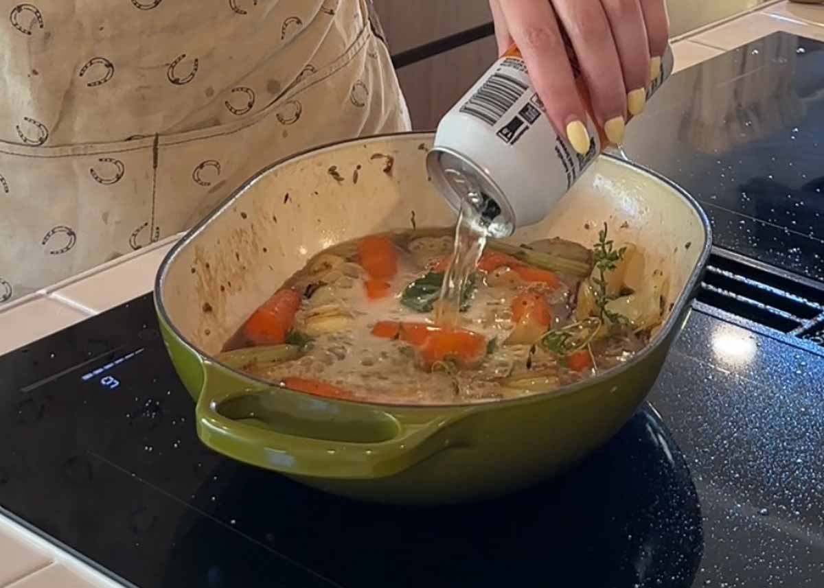 adding beer to braising liquid and vegetables for pork shoulder