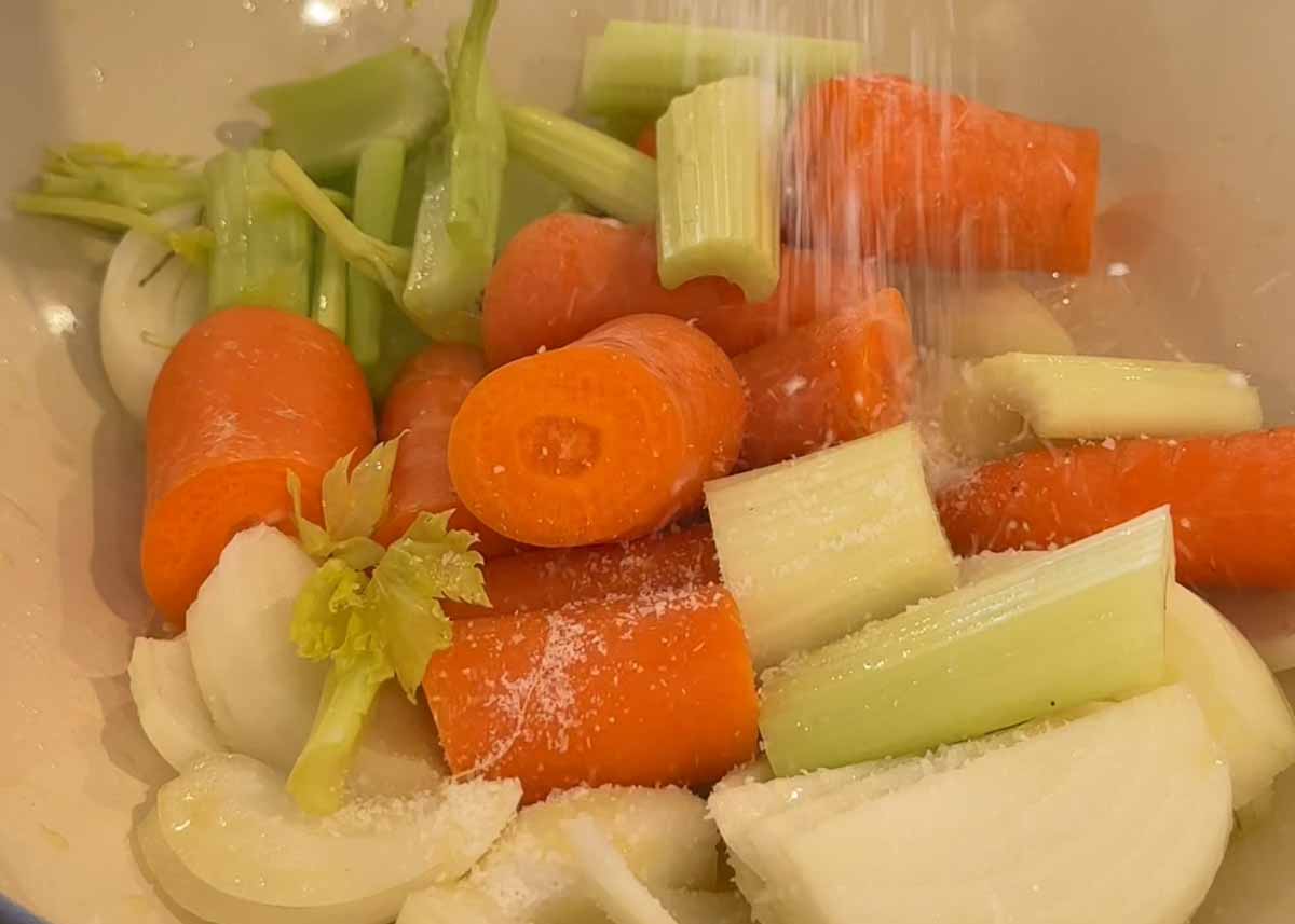 Carrots, celery and onion cooking in a pot as the base for beer braised pork shoulder