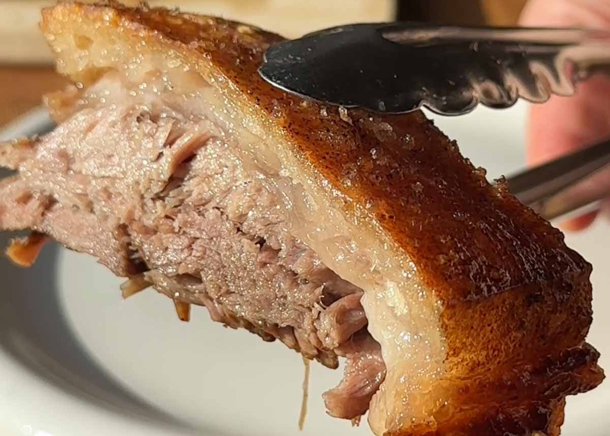 Close up of sliced beer braised pork shoulder with crispy crackling and tender meat
