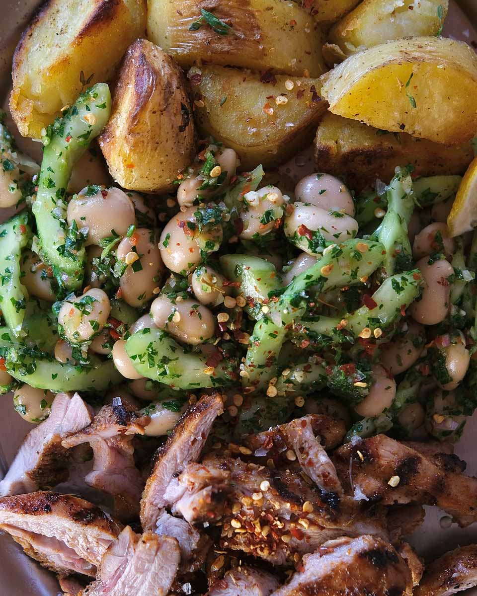 Close up of butter bean salad tossed in fresh parsley and coriander chimichurri dressing