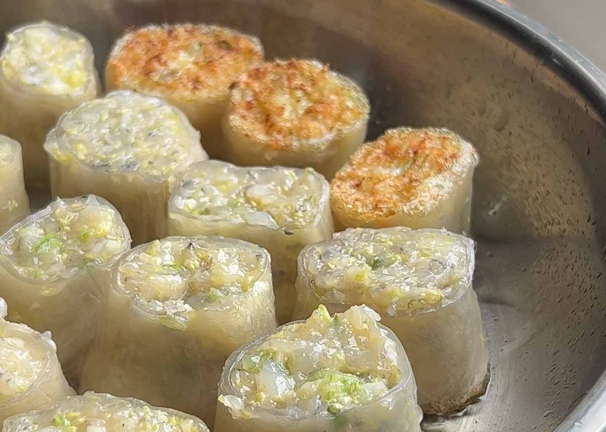 prawn dumplings getting crispy in frypan