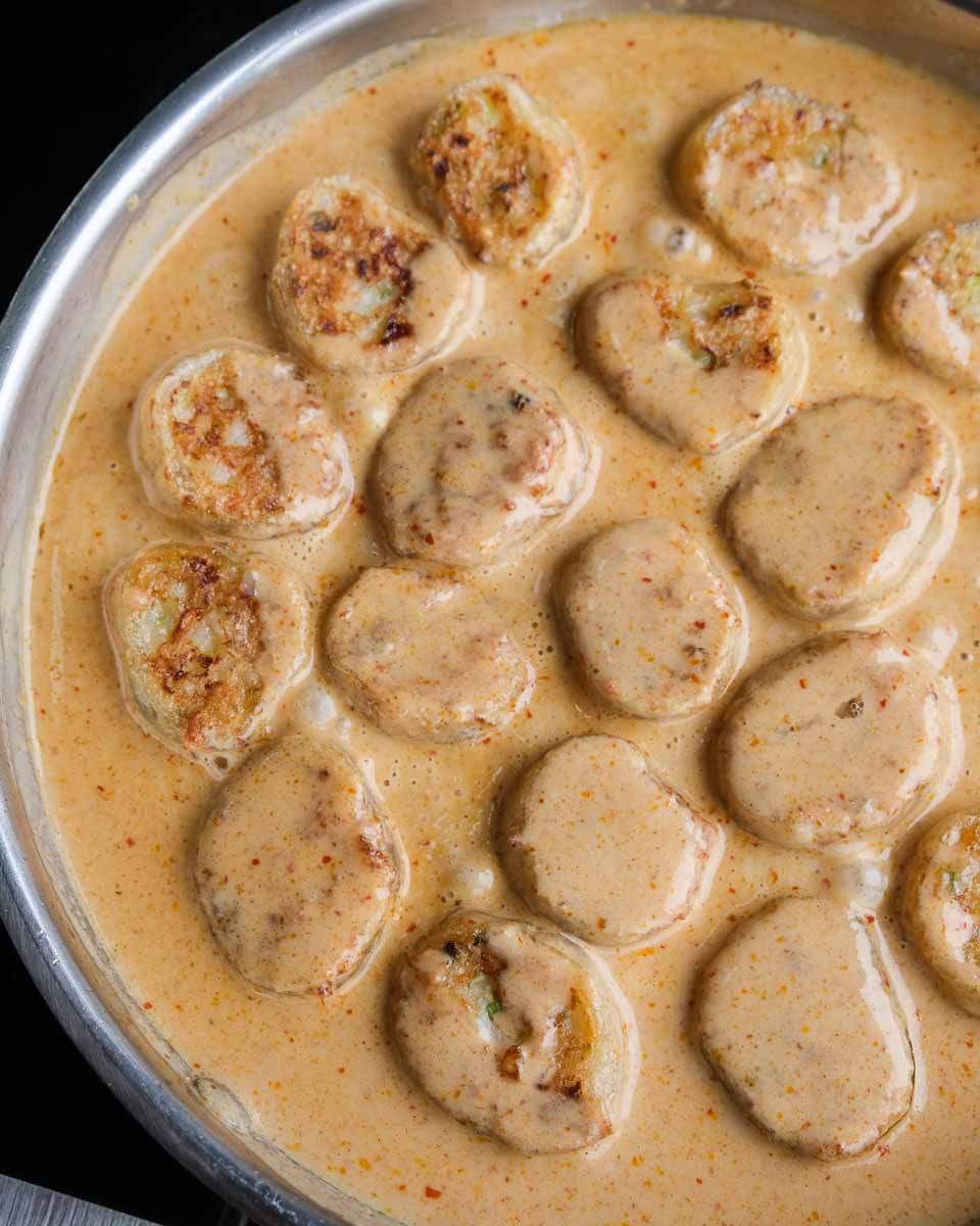 Crispy rice paper prawn dumplings served with Thai red curry sauce poured over the top