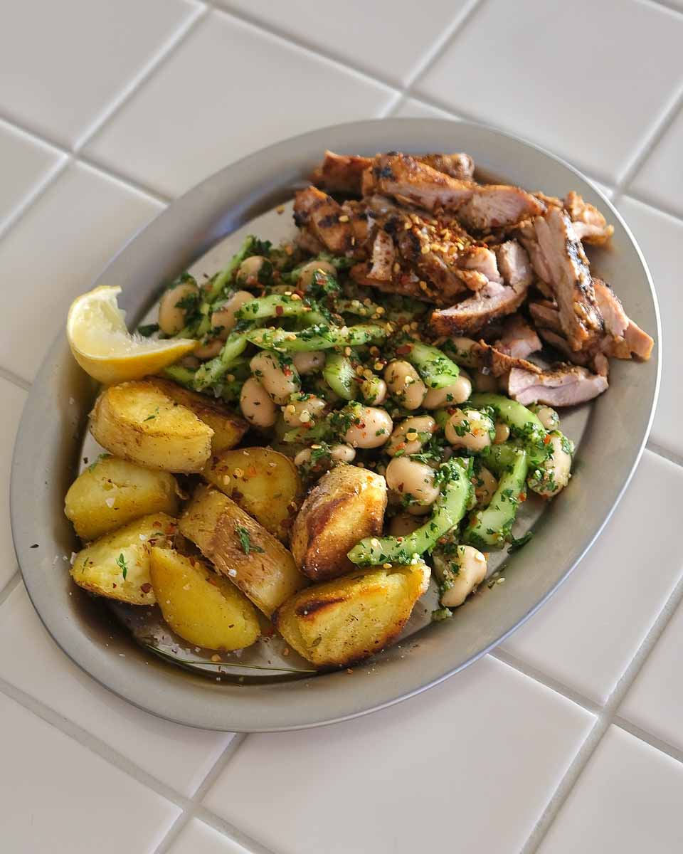 Grilled chicken served with chimichurri butter bean salad and crispy chat potatoes