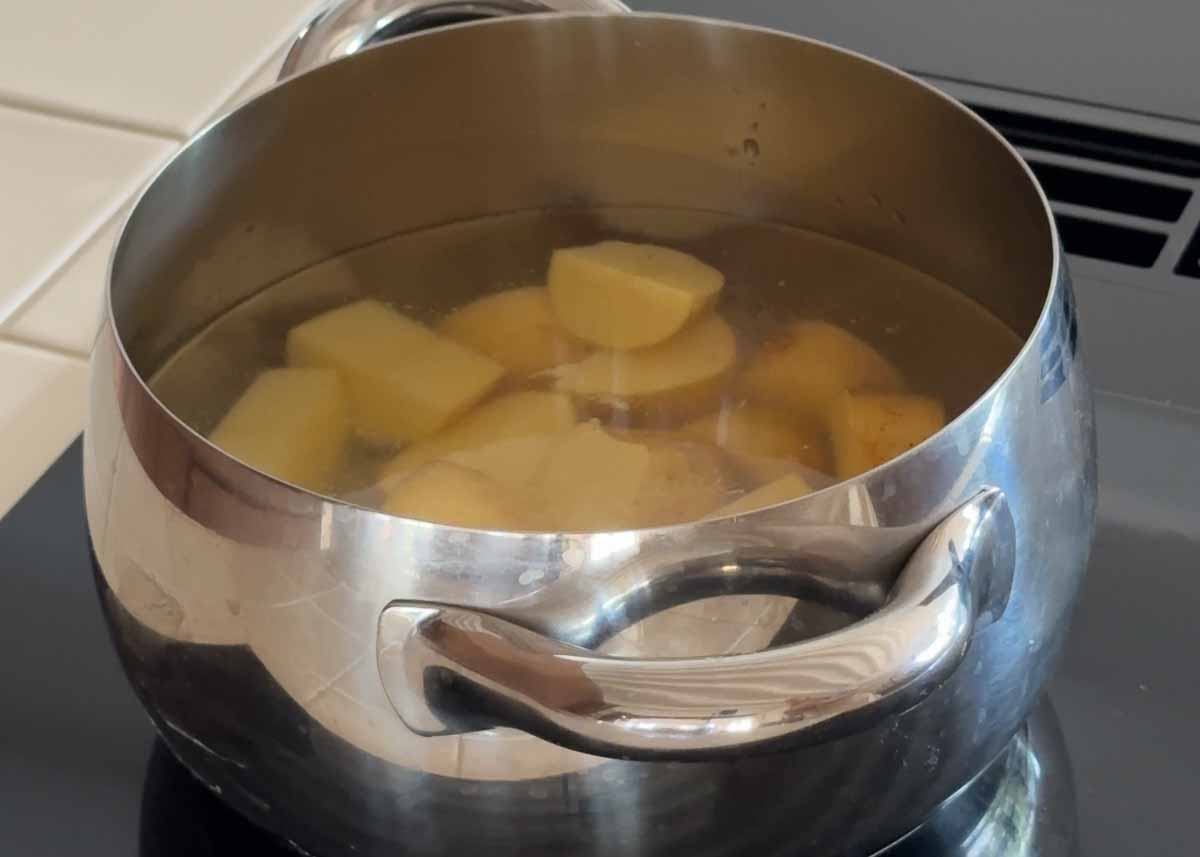 Potatoes boiling in salted water before being pan fried