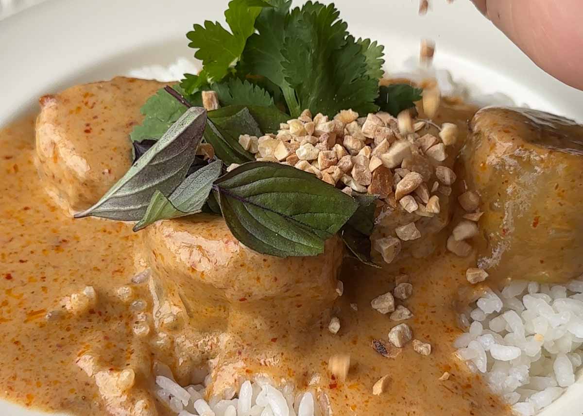 Crispy prawn dumplings served with red curry sauce and fresh herbs