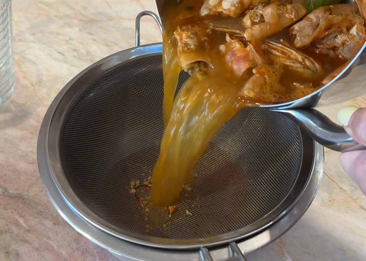 Straining homemade prawn stock made from prawn heads and shells