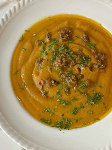 Close up of creamy pumpkin and sweet potato split pea soup with curry butter drizzle feature image