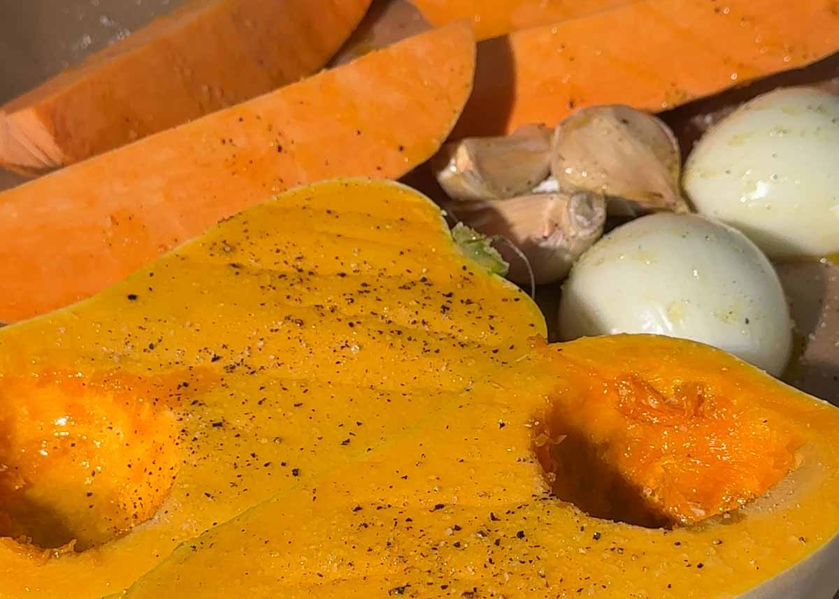 Pumpkin, sweet potato, onion and garlic prepared on a tray for roasting