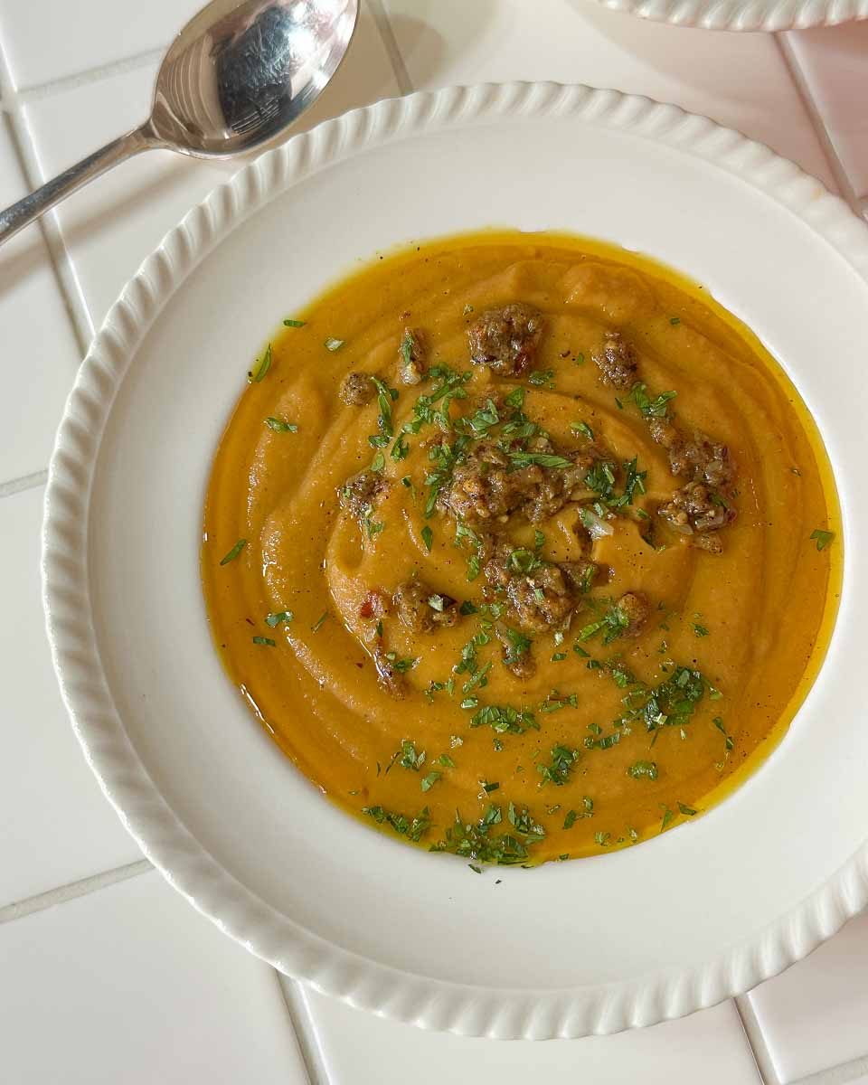 Roasted sweet potato and pumpkin split pea soup topped with curry butter and herbs