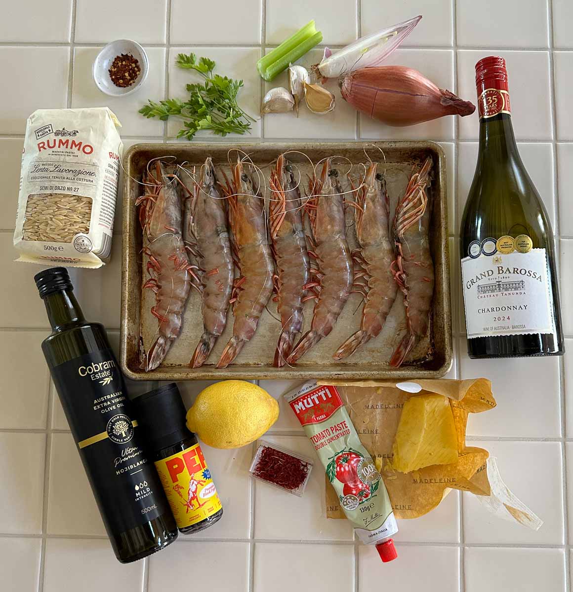 Ingredients for saffron king prawn orzo including raw prawns, orzo, garlic, lemon, white wine and saffron