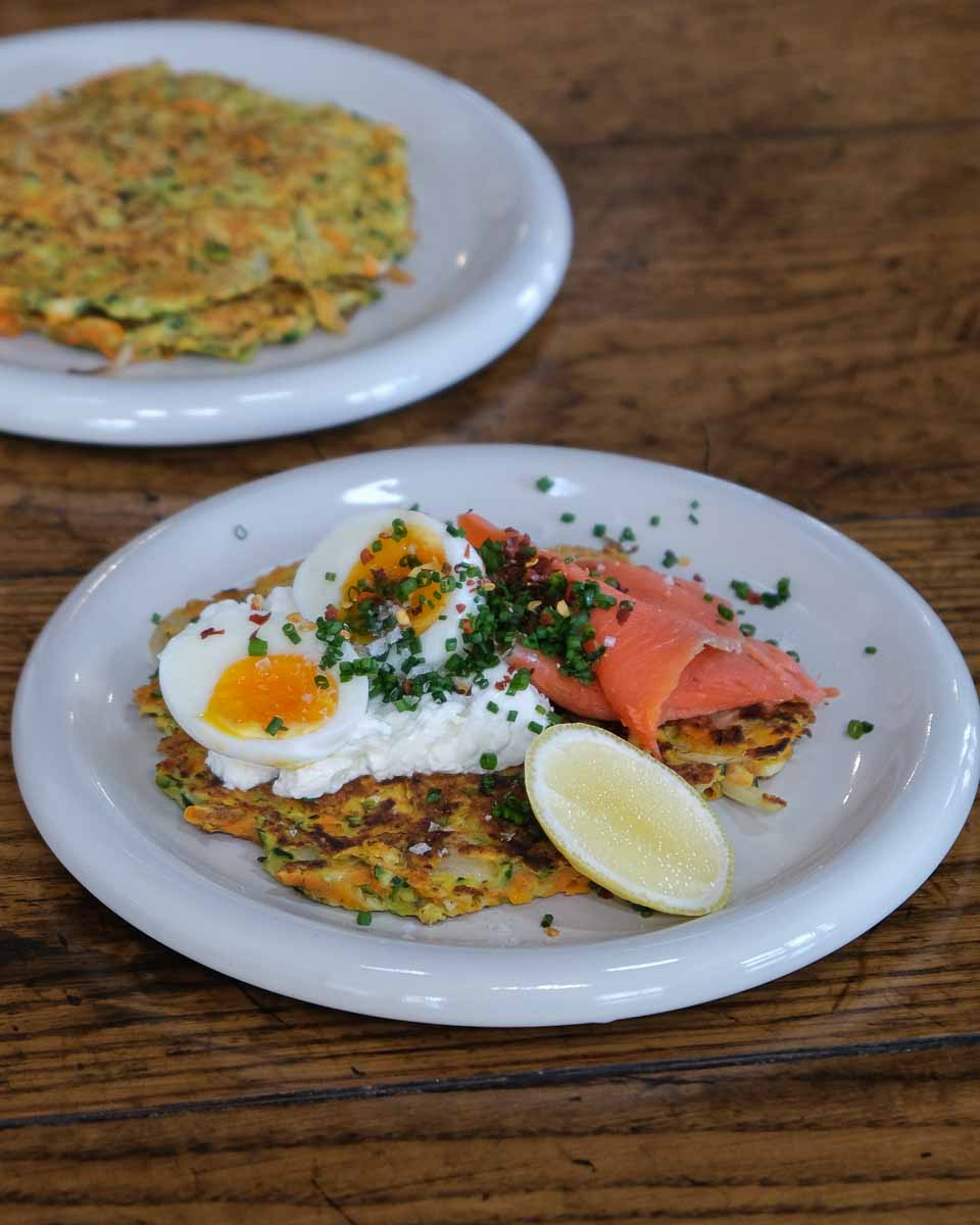 Zucchini carrot and parmesan fritters served with egg, smoked salmon and herbs