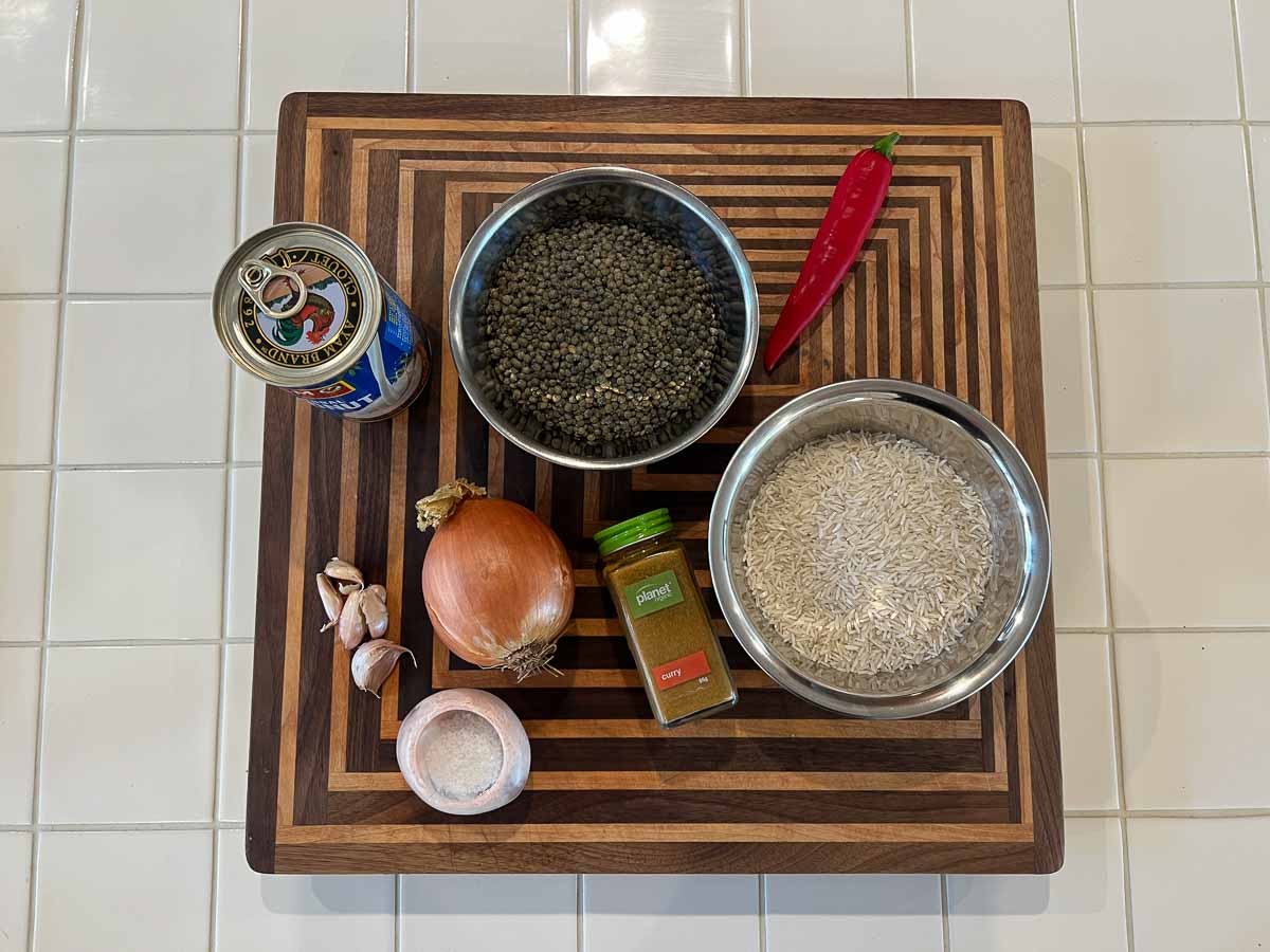 Ingredients for creamy coconut lentil curry including puy lentils, onion, garlic, chilli, coconut milk and curry powder