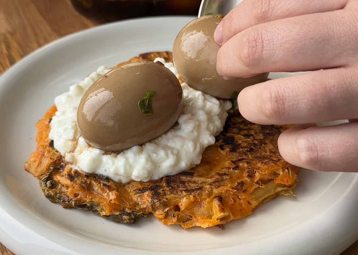 Assembling kimchi pancake with cottage cheese and Korean marinated egg