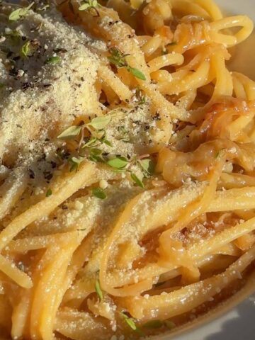Close up of caramelised onion and anchovy spaghetti with glossy butter sauce