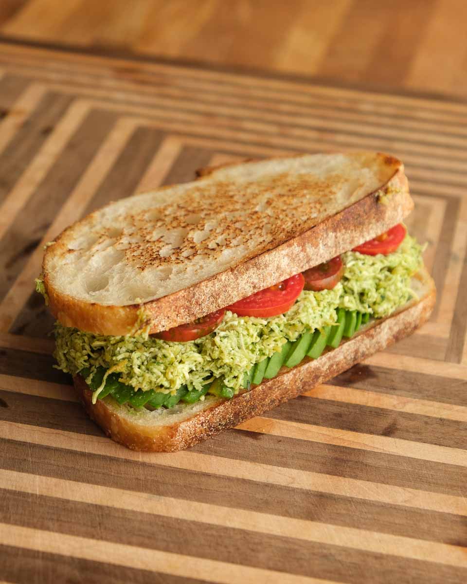 Smashed tofu and avocado mixture being prepared for sandwich filling