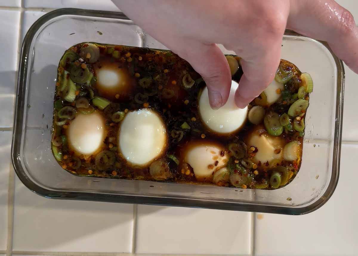 Soft boiled eggs soaking in soy garlic marinade with spring onions