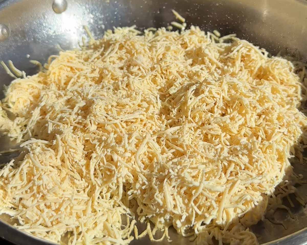 Grated tofu frying in a pan until golden for a tofucado pesto toasted sandwich