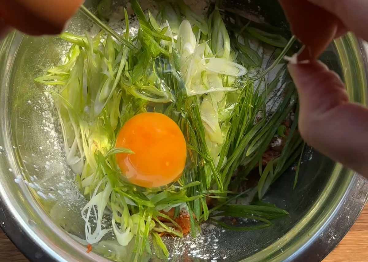 Mixing kimchi pancake batter with chopped kimchi and egg