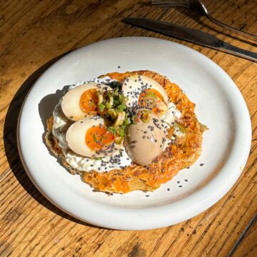 Close up of crispy kimchi pancake topped with jammy Korean marinated eggs