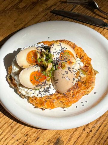 Close up of crispy kimchi pancake topped with jammy Korean marinated eggs