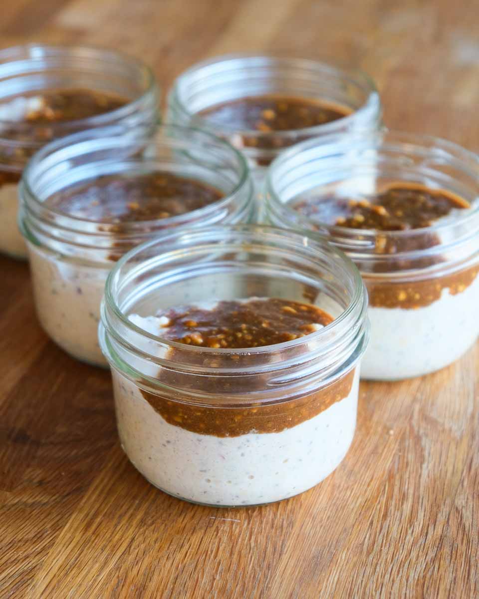Meal prepped miso caramel bircher muesli in glass jars with caramel swirl on top
