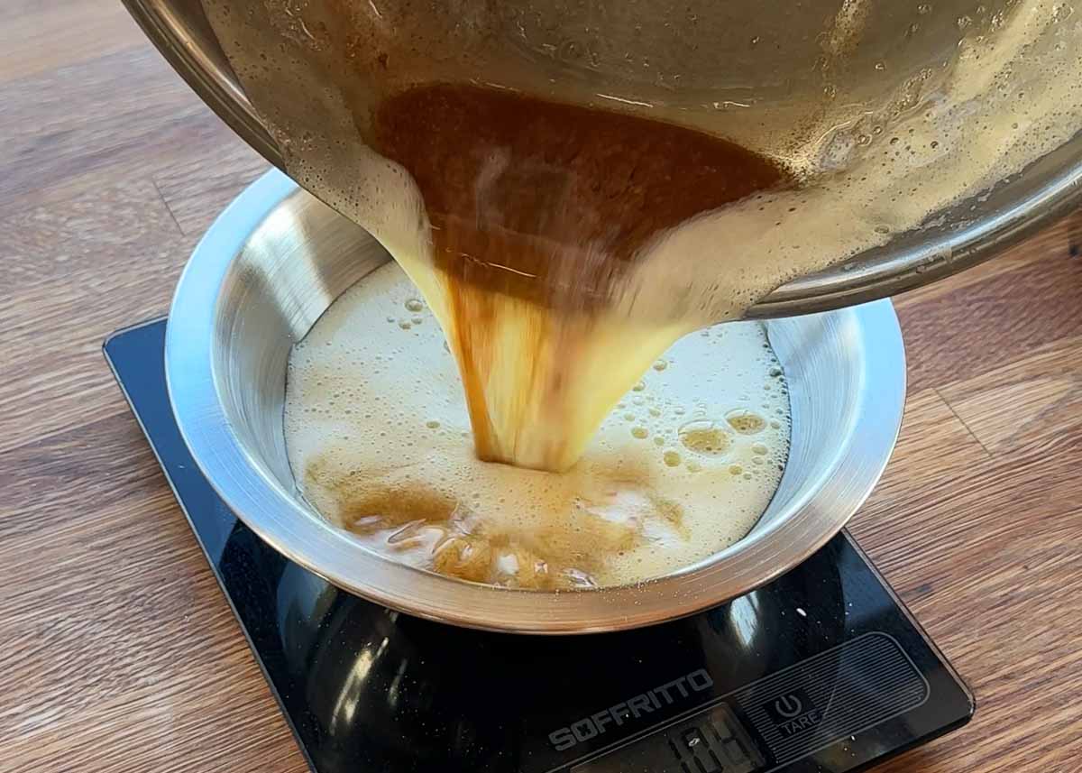 pouring hot browned butter into bowl for anzac style biscuit mixture