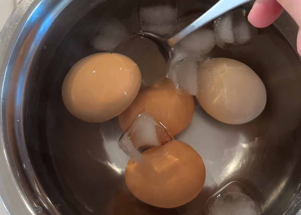 Soft boiled eggs cooling in an ice bath before peeling