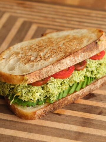 Tofucado pesto toasted sandwich with crispy golden bread, smashed avocado tofu filling and fresh tomato