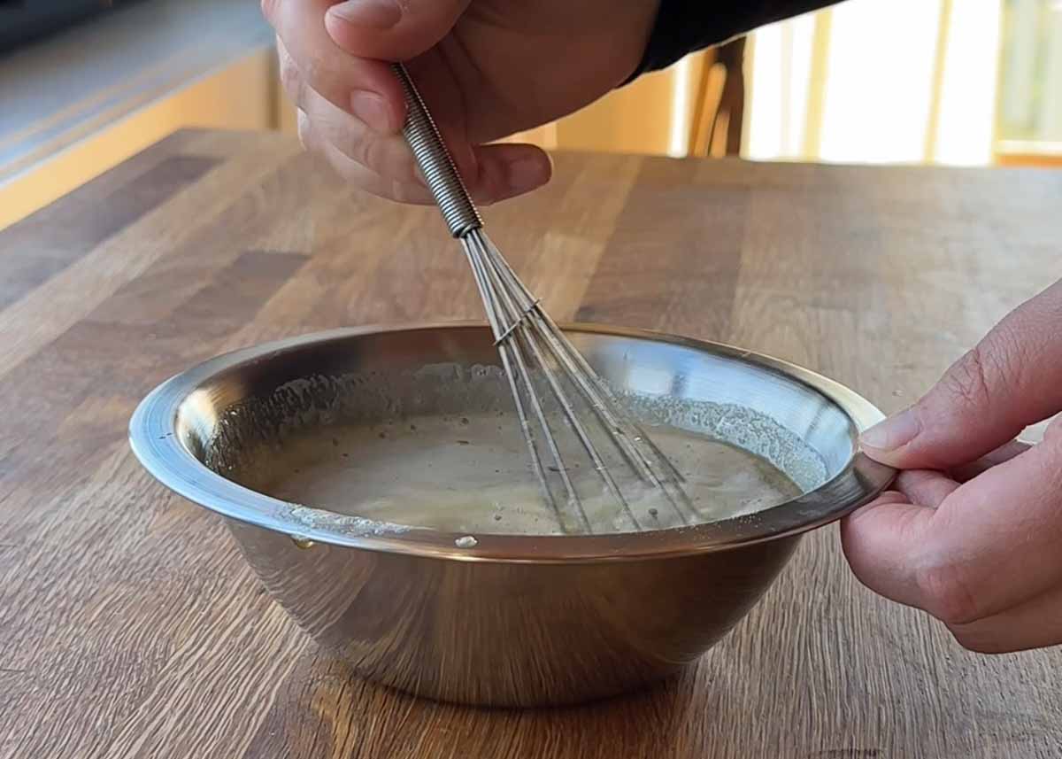 whisking golden syrup and bicarbonate mixture for oat coconut biscuits
