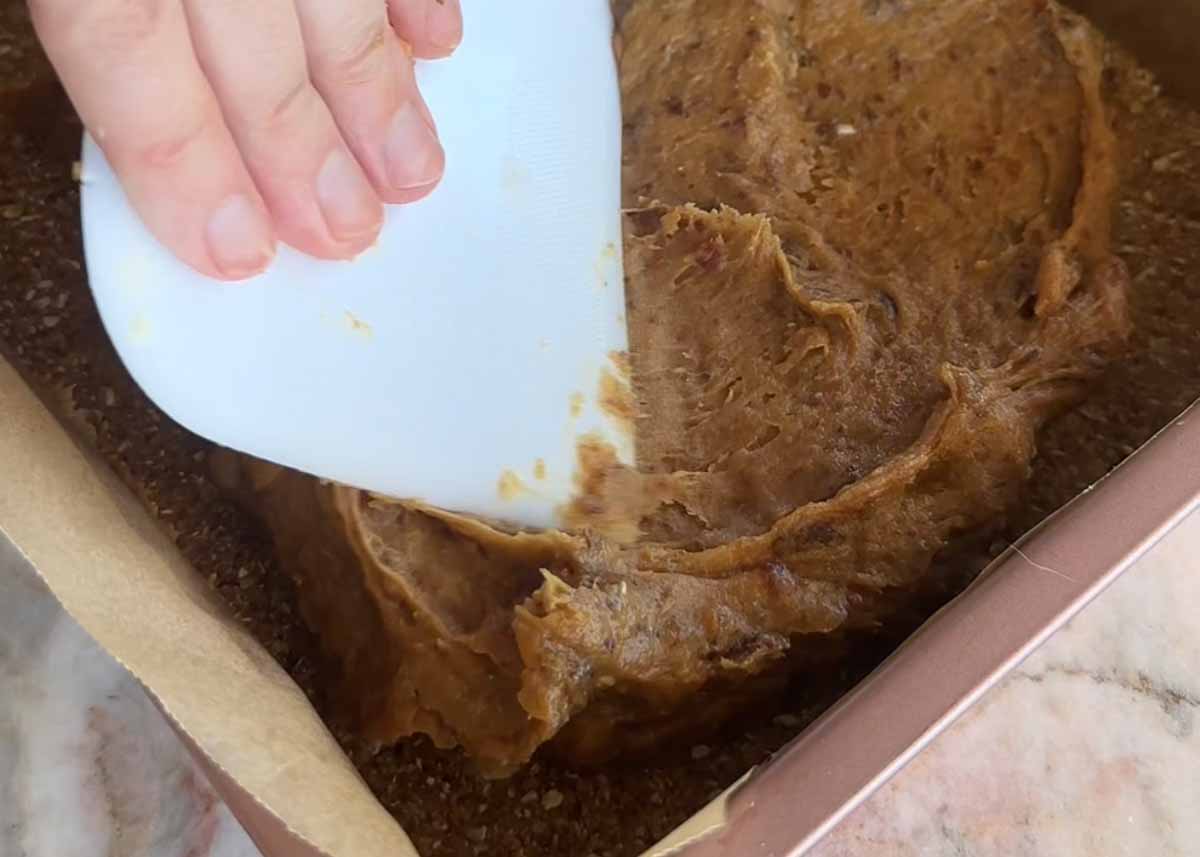 Spreading the miso tahini caramel filling over the base.