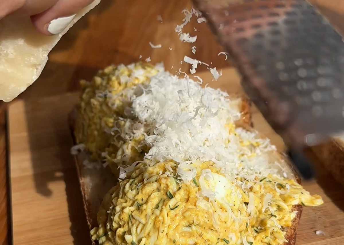 Curried grated egg toastie topped with grated cheese before cooking