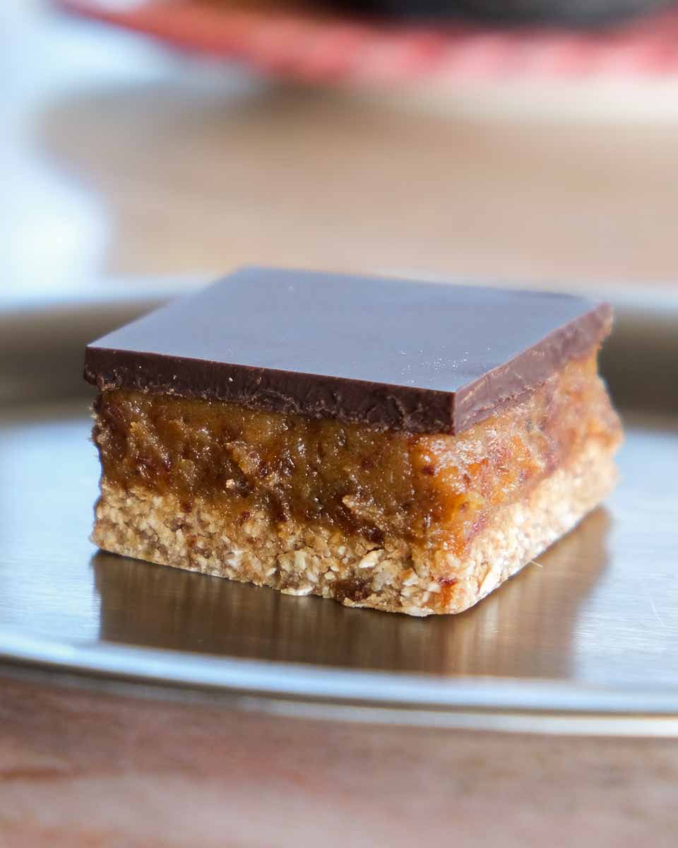 Close up of caramel slice showing the oat base and sticky caramel filling.
