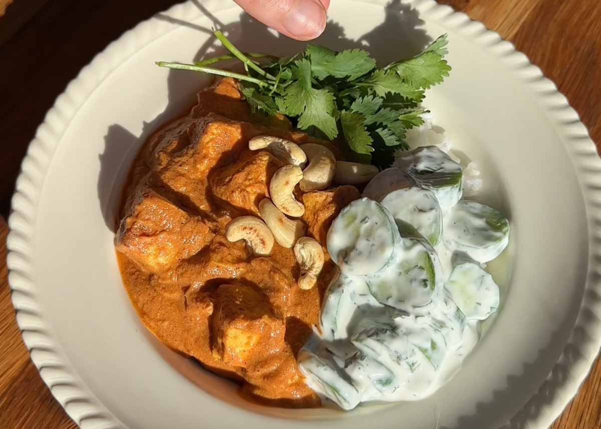 Butter paneer one tray bake served with cucumber yoghurt salad and fresh herbs