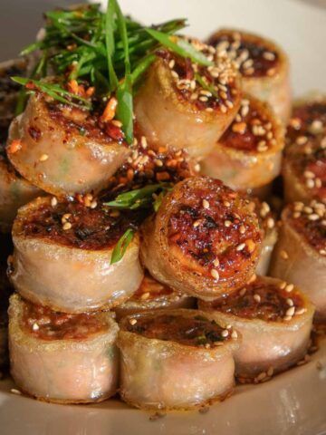 Crispy rolled pork rice paper dumplings served on a plate with golden crispy edges.