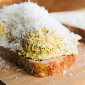 Golden crispy curried grated egg toastie with melted filling. feature image