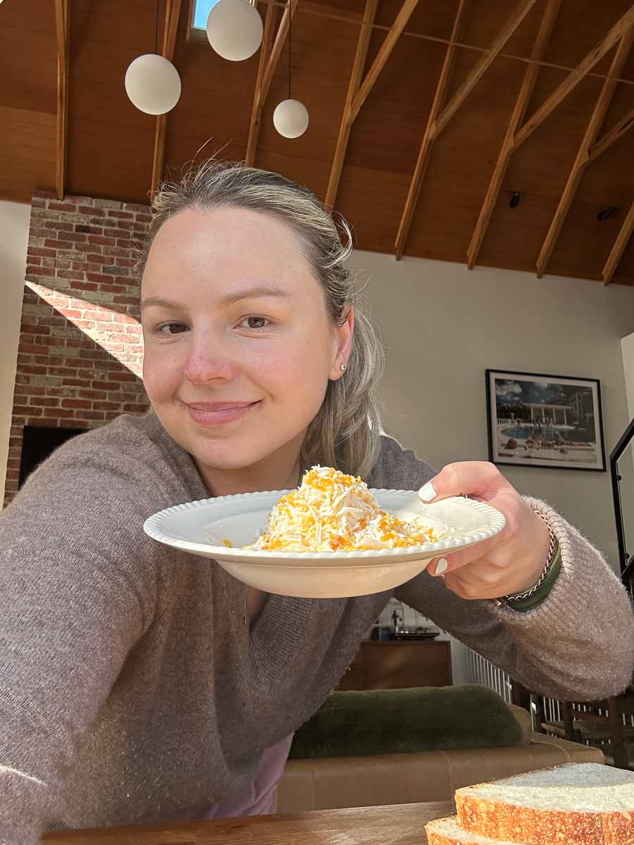 sezzy brown holding curried grated egg toastie explaining why she loves grating eggs for recipes