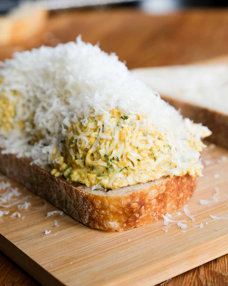 Grated boiled egg piled onto bread for curried egg toastie filling