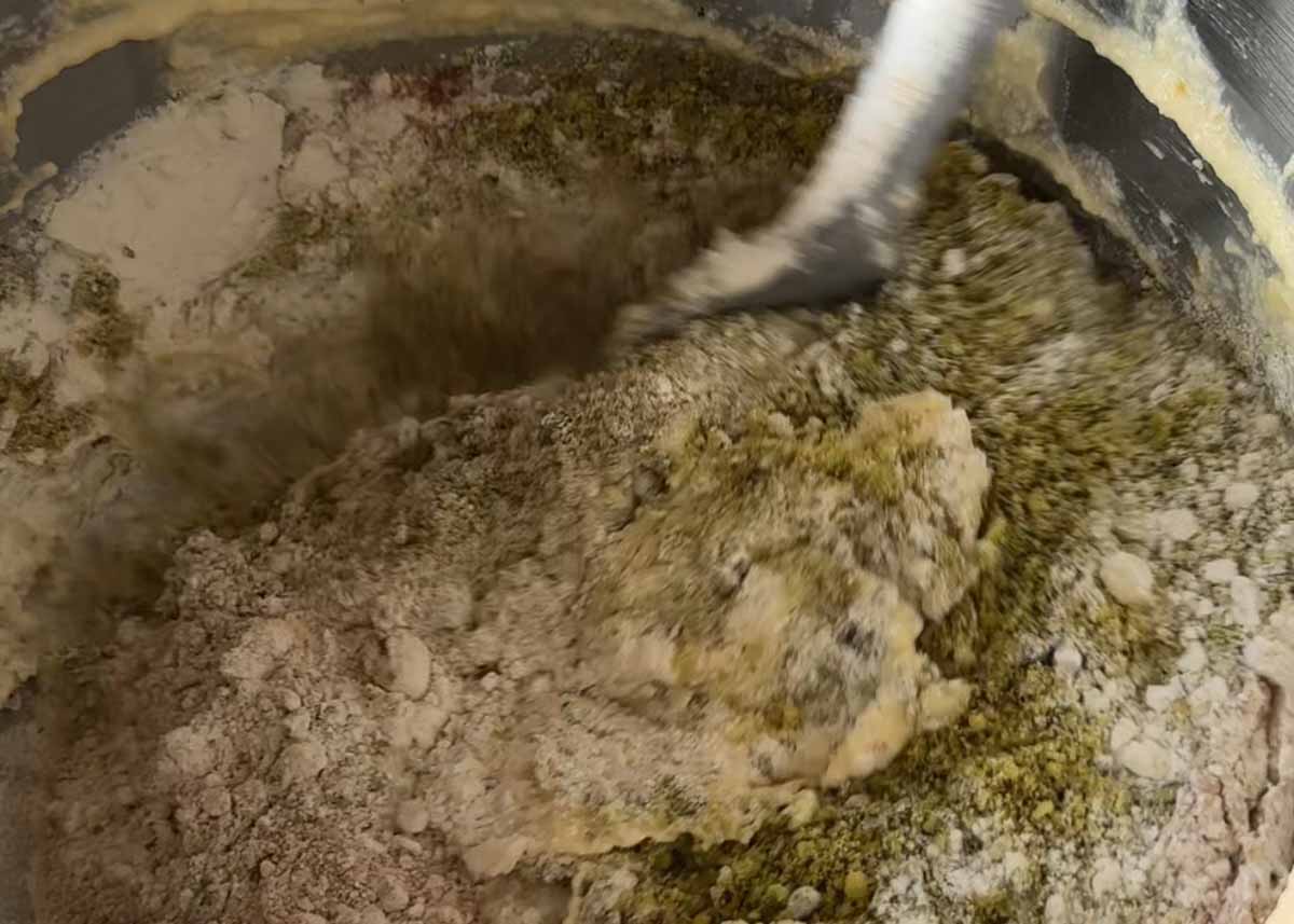 Folding flour and pistachios into spiced pistachio cake batter.