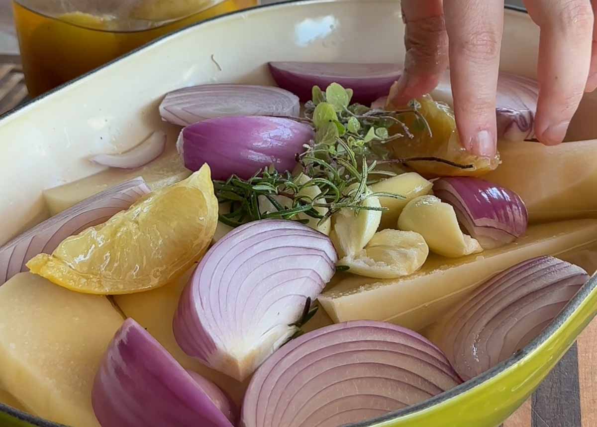 Potatoes, preserved lemon, garlic and onion layered in a baking dish.