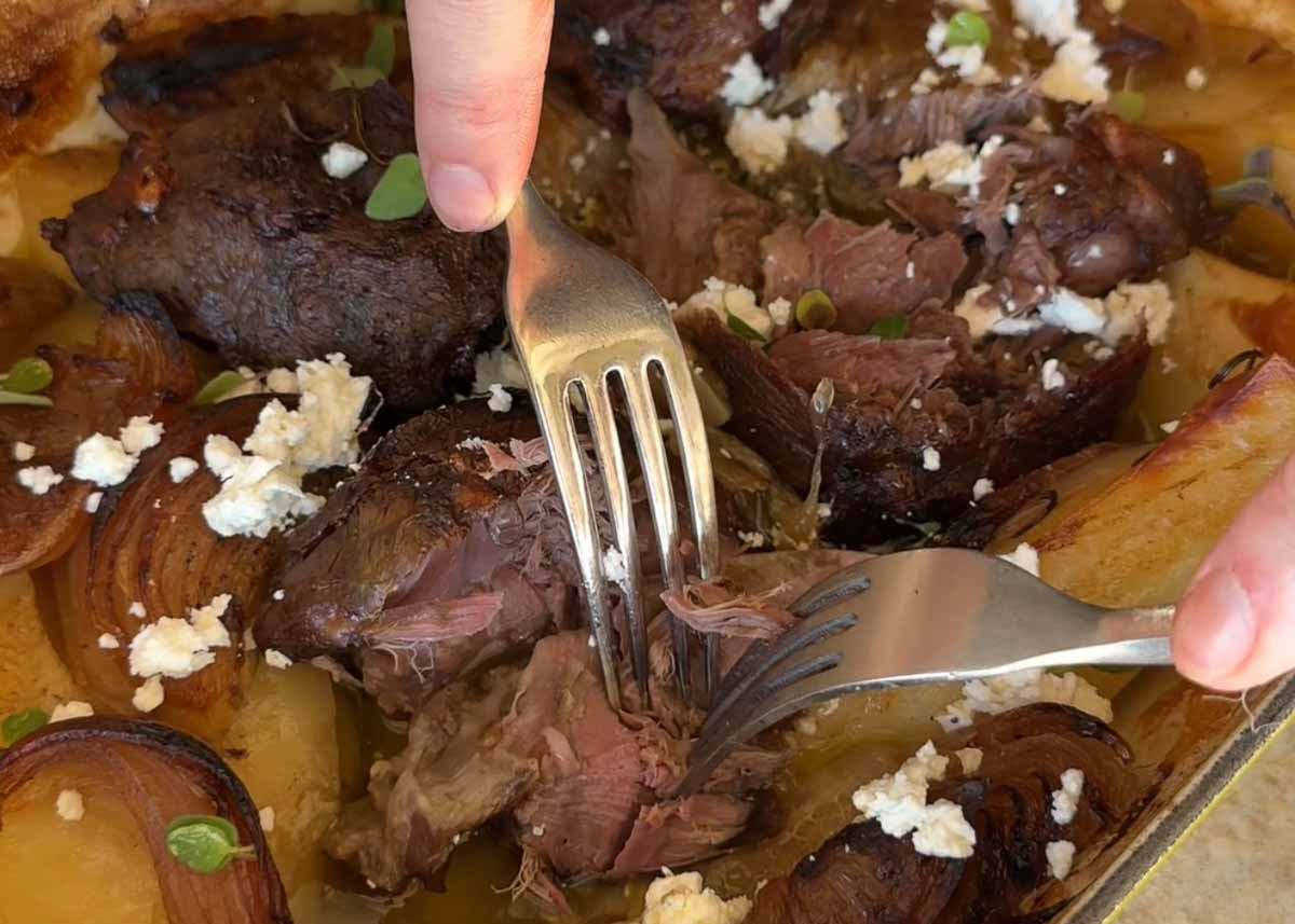 ender pull-apart lamb shanks being served with potatoes and feta.