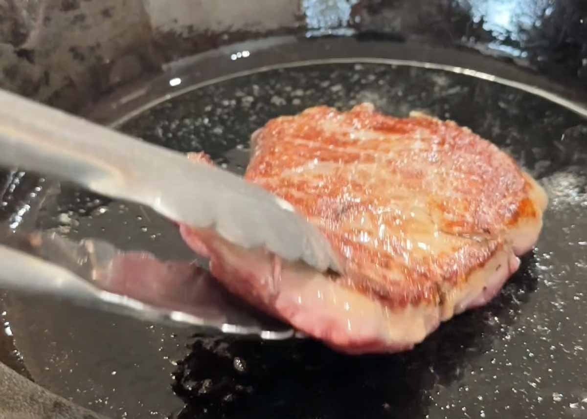 Eye fillet steak searing in pan until golden brown