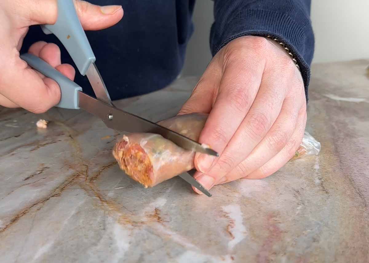Slicing rolled pork rice paper logs into bite-sized dumplings