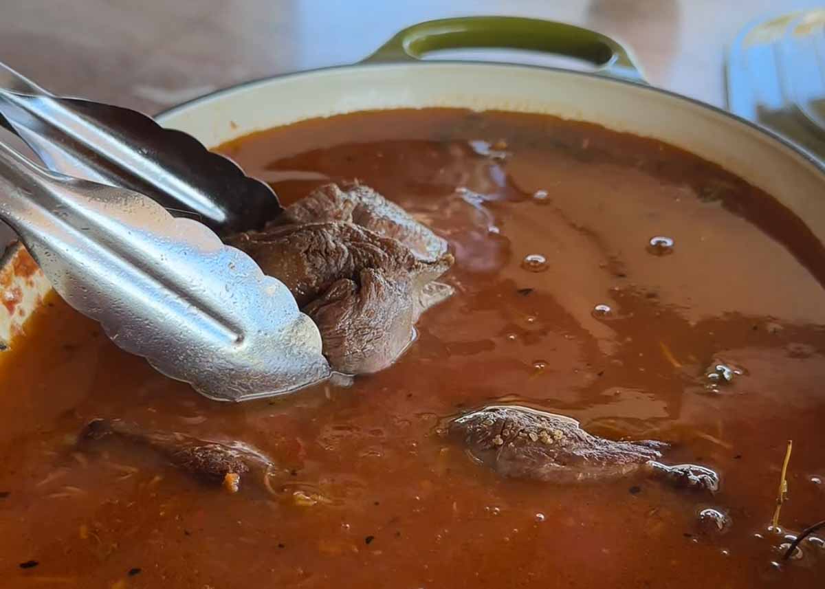 Boneless lamb shank slow cooking in rich rosé tomato ragu sauce