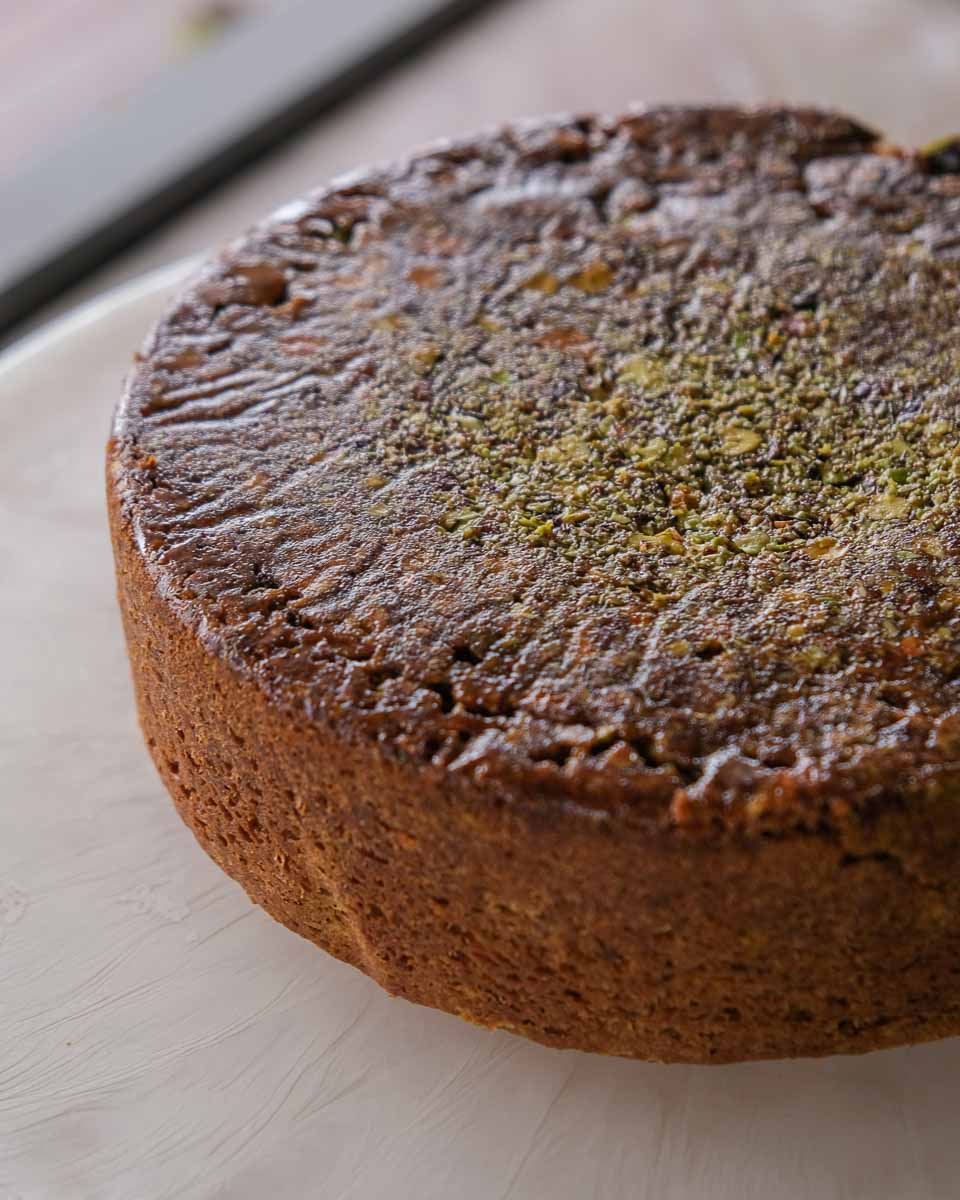 Side view of spiced pistachio upside down cake showing the soft crumb and caramelised top.