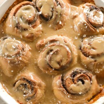 Soft brown butter cardamom sourdough scrolls with salted maple glaze and caramelised edges.