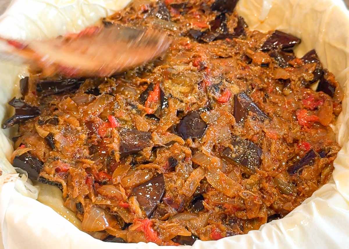 Eggplant börek assembled in a baking dish before being topped with filo pastry.
