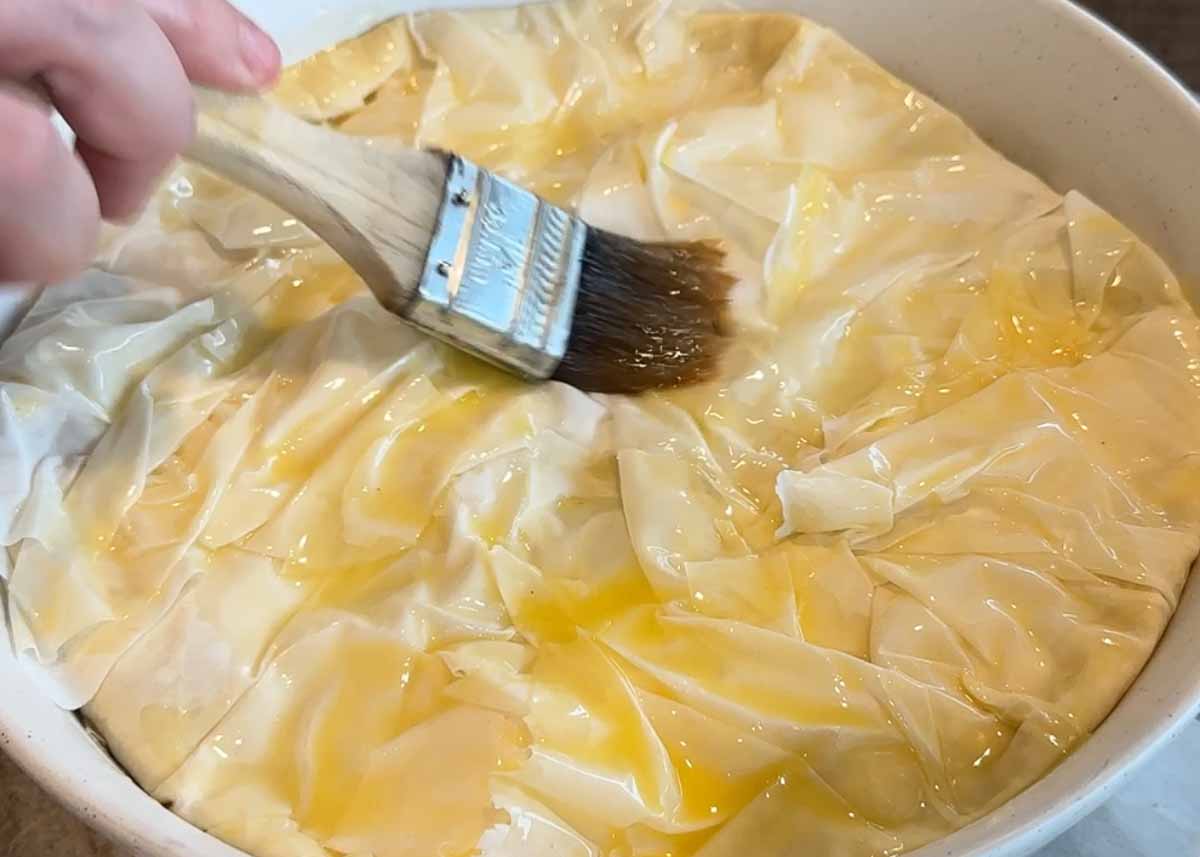 Filo pastry brushed with butter before baking into a golden eggplant börek.